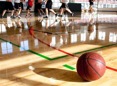 Adults playing pick-up basketball in a gym